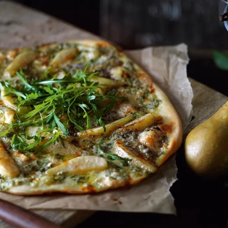 Pizza z gruszką i serem roquefort podawana z rukolą